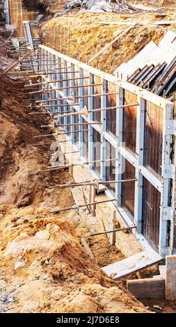 Konstruktionsschalung zum Betonieren von Nahaufnahmen vertikal Foto. Der Einsatz von Schalungen und Eisenarmierungsstäben oder Resten beim Bau der Fou Stockfoto