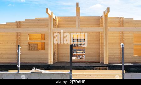 Modernes Holzhaus aus profiliertem Schichtholz. Die Wand eines Wohngebäudes aus geklebtem Schichtholz oder aus Lamellenmaterial aus der Nähe. Konstruktio Stockfoto