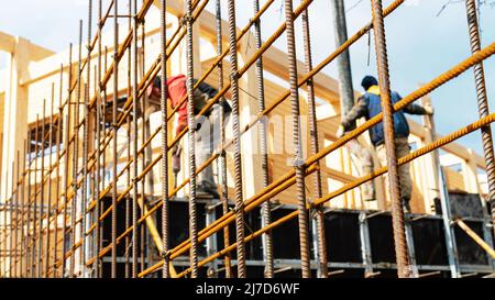 Band Eisen rebar Nahaufnahme. Vor dem Betonieren auf der Baustelle wird die Bewehrungsstange gebindet. Arbeiter Beton eine Stützmauer am Bau Stockfoto