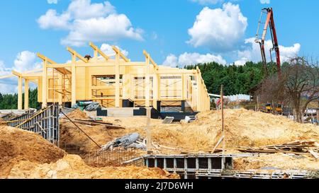 Bau eines Holzhauses aus geklebtem Schichtholz. Baustelle für Doppelbalkenhäuser. Betonieren der Stützmauer, Zaunfundament durch Konz Stockfoto