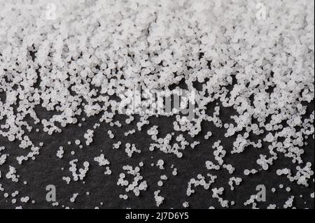 Weiß viele Polymergranulate auf schwarzem matten Hintergrund Stockfoto