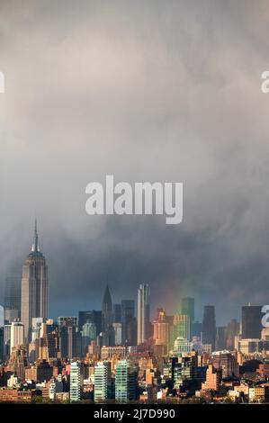 Dramatischer Himmel und Regenbogen über der Skyline von Midtown Manhattan Stockfoto