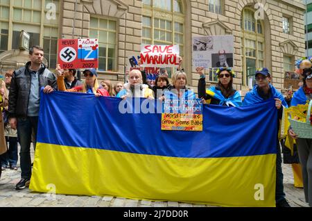 Die Teilnehmer halten am 8. Mai 2022 im Bowling Green Park, New York City, eine massive ukrainische Flagge, um ihre Unterstützung für die Ukraine zu zeigen. Stockfoto