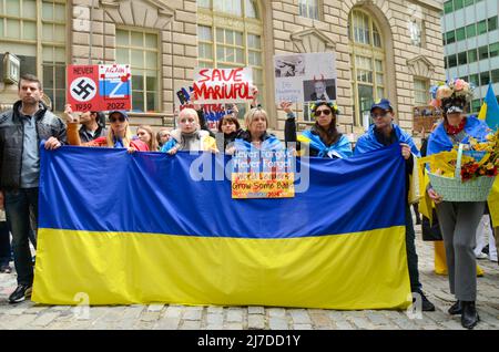 Die Teilnehmer halten am 8. Mai 2022 im Bowling Green Park, New York City, eine massive ukrainische Flagge, um ihre Unterstützung für die Ukraine zu zeigen. Stockfoto