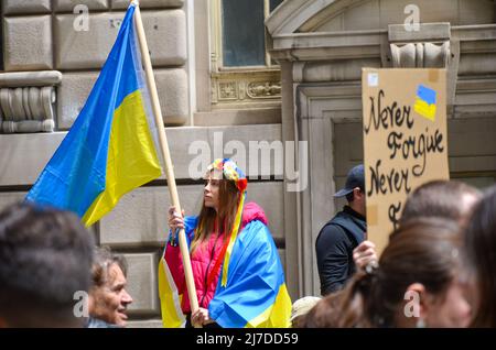 Eine Frau hält am 8. Mai 2022 im Bowling Green Park in New York City eine ukrainische Flagge, um sich solidarisch mit der Ukraine zu zeigen. Stockfoto