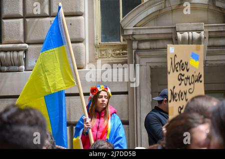 Eine Frau hält am 8. Mai 2022 im Bowling Green Park in New York City eine ukrainische Flagge, um sich solidarisch mit der Ukraine zu zeigen. Stockfoto