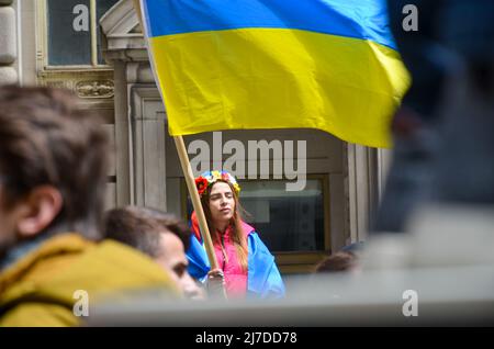 Eine Frau hält am 8. Mai 2022 im Bowling Green Park in New York City eine ukrainische Flagge, um sich solidarisch mit der Ukraine zu zeigen. Stockfoto