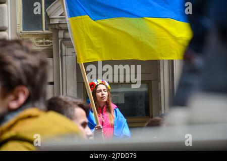 Eine Frau hält am 8. Mai 2022 im Bowling Green Park in New York City eine ukrainische Flagge, um sich solidarisch mit der Ukraine zu zeigen. Stockfoto