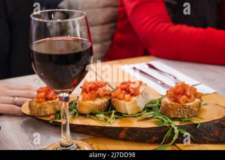 Nahaufnahme eines Tellers mit Bruschette und einem Glas Rotwein Stockfoto