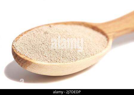 Aktive Trockenbackhefe-Granulat in Holzlöffel. Stockfoto