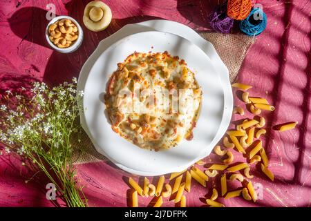 Hühnerkäse Cashew Nüsse Pasta in einem Teller Draufsicht auf Holz Hintergrund Stockfoto