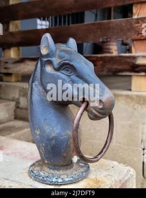 Nahaufnahme eines antiken gusseisernen Pferdes mit Ring-Anhitching-Säule Stockfoto