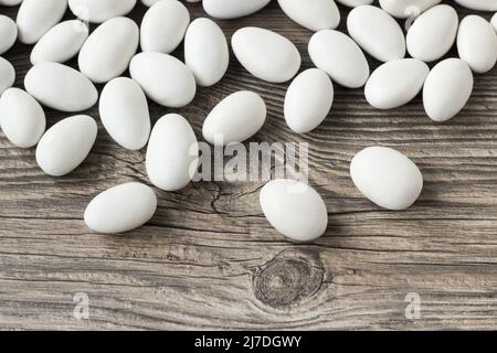 Traditionelle, weiß gefärbte, mit Schokolade überzogene Mandel-Bonbons auf Holzoberfläche Stockfoto