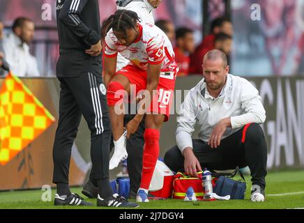 08. Mai 2022, Sachsen, Leipzig: Fußball: Bundesliga, Spieltag 33., RB Leipzig - FC Augsburg in der Red Bull Arena. Leipzigs Spieler Christopher Nkunku wechselt während des Spiels die Socken. Foto: Jan Woitas/dpa - WICHTIGER HINWEIS: Gemäß den Anforderungen der DFL Deutsche Fußball Liga und des DFB Deutscher Fußball-Bund ist es untersagt, im Stadion und/oder des Spiels aufgenommene Fotos in Form von Sequenzbildern und/oder videoähnlichen Fotoserien zu verwenden oder zu verwenden. Stockfoto