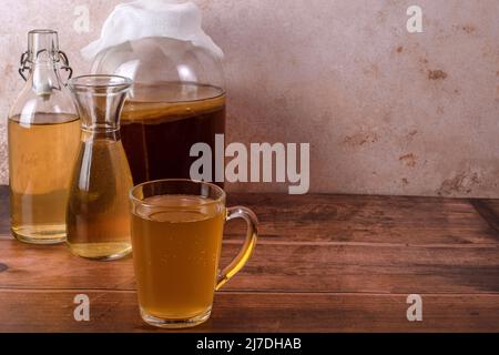 Teepilz in Gläsern auf Holzhintergrund. Kombucha wird vorbereitet. Stockfoto