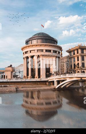 Wunderschöne Spiegelung des Archäologischen Museums der Republik Mazedonien bei Sonnenuntergang in Skopje, Nord-Mazedonien. Stockfoto