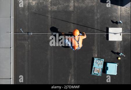 Installation der Blitzschutzstange für Wohngebäude durch die Luftaufnahme eines professionellen Mitarbeiters. Stockfoto