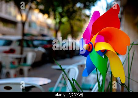 Buntes Windrad. Das Windrad oder die Windmühle in der Straße dekoratives Objekt des Cafés. Konzeptionelle Cafés oder Restaurants Hintergrundbild. Selektiver Fokus. Stockfoto