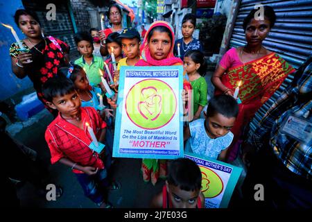 Kalkutta, Indien - am 8. Mai 2022 halten indische Sozialaktivisten zusammen mit ihren Kindern Plakate und entzündeten Kerzen während einer Demonstration, um am Muttertag in Kalkutta auf den Blutzustand und die Thalassämie aufmerksam zu machen. Indische Sozialaktivisten demonstrierten anlässlich des Internationalen Thalassämie-Tages, der ein Datum mit dem Muttertag teilt, um das Bewusstsein für den Blutzustand und die Thalassämie zu schärfen. Der Muttertag wird begangen, um die Existenz der Mütter und ihre Bedeutung im menschlichen Leben zu ehren. Stockfoto