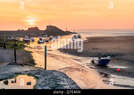 Ein verschwommener Abschluss des Tages, wenn die Sonne über dem malerischen Wellenbrecher in Bude im Nordosten von Cornwall untergeht. Stockfoto