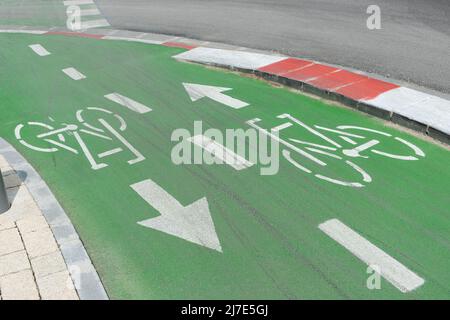 Fahrradschild auf Straßenbelag lackiert. Grün lackierte Fahrradwege in Israel. Fahrbahnteil nur für Radfahrer reserviert. ECO Transportkonzept. Stockfoto