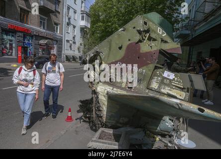 Kiew, Ukraine - 08. Mai 2022 Menschen sahen die Überreste eines russischen Flugzeugs, das vor dem Nationalen Militärhistorischen Museum der Ukraine installiert war. Russische militärische Ausrüstung, die vom ukrainischen Militär zerstört wurde, wird vorübergehend im Nationalen Militärhistorischen Museum der Ukraine ausgestellt. Die Ausstellung ist dem russisch-ukrainischen Krieg gewidmet Stockfoto