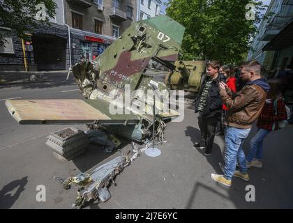 Kiew, Ukraine - 08. Mai 2022 Menschen sahen die Überreste eines russischen Flugzeugs, das vor dem Nationalen Militärhistorischen Museum der Ukraine installiert war. Russische militärische Ausrüstung, die vom ukrainischen Militär zerstört wurde, wird vorübergehend im Nationalen Militärhistorischen Museum der Ukraine ausgestellt. Die Ausstellung ist dem russisch-ukrainischen Krieg gewidmet Stockfoto