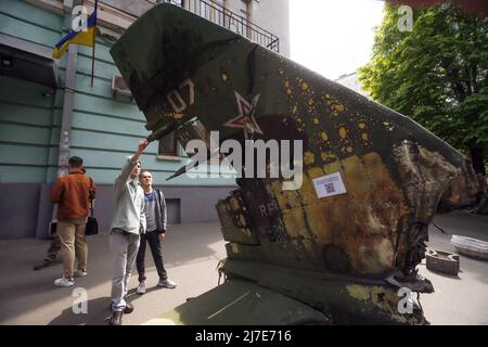 Kiew, Ukraine - 08. Mai 2022 Menschen sahen die Überreste eines russischen Flugzeugs, das vor dem Nationalen Militärhistorischen Museum der Ukraine installiert war. Russische militärische Ausrüstung, die vom ukrainischen Militär zerstört wurde, wird vorübergehend im Nationalen Militärhistorischen Museum der Ukraine ausgestellt. Die Ausstellung ist dem russisch-ukrainischen Krieg gewidmet Stockfoto