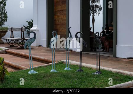 Einige Metallreiher-Vögel wurden auf einem kleinen Grasfeld vor einem lokalen Geschäft mit handgefertigten Gegenständen in der Inconfidentes Street zum Verkauf angeboten. Stockfoto