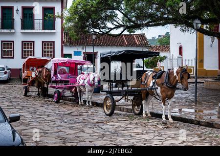 Bunte Wagen, die an Pferde befestigt waren, hielten an der Silvio Vasconcelos Straße vor dem Largo das Forras Platz und warteten auf Touristen für eine Dorftour. Stockfoto