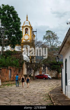 Die bergauf gepflasterte Padre Toledo Straße mit Teilblick auf den Santo Antonio Mutter Kirchturm hinten im historischen Zentrum von Tiradentes. Stockfoto