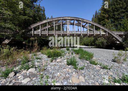 Die verlassene Brücke überspannt den von der Dürre heimgesuchten Van Duzen River entlang des State Highway 36 in Nordkalifornien. Stockfoto