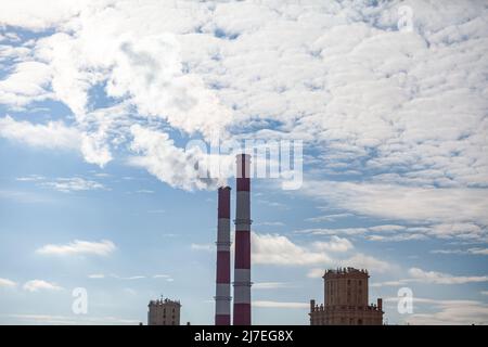 CHP in der Stadt. Aus den Wärmerohren des Kraftwerks steigt Rauch in den Himmel. Rohr aus Blockheizkraftwerk KWK oder Kraft-Wärme-Kopplung gegen BA Stockfoto