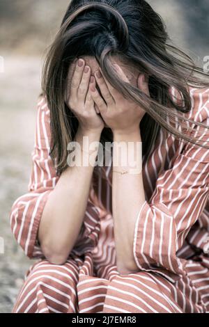 Gestresste Frau, Kopf in den Händen, weinend Stockfoto