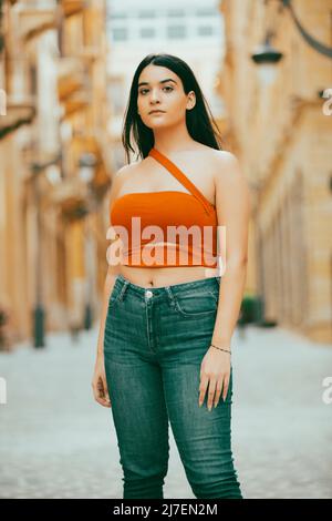 Schöne Frau, die auf der Straße steht und die Kamera anschaut Stockfoto