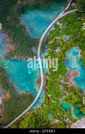 Plitvice, Kroatien - Luftaufnahme von oben auf einen Holzsteg im Nationalpark Plitvicer Seen an einem hellen Sommertag mit türkisfarbenem Wasser und kleinem Wat Stockfoto