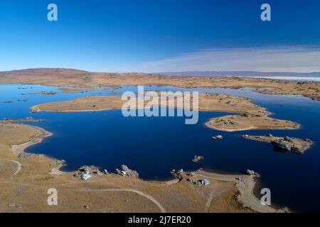 Fischerhütten und Poolburn Dam, Central Otago, South Island, Neuseeland - Drohnenantenne Stockfoto