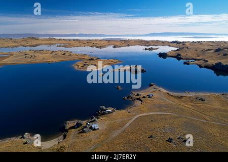 Fischerhütten und Poolburn Dam, Central Otago, South Island, Neuseeland - Drohnenantenne Stockfoto