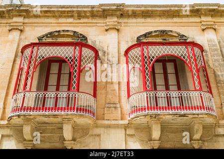 Blick auf ein paar hübsche rote Balkone in Mdina, der alten Hauptstadt von Malta, die im April 2022 gesehen wurde. Stockfoto