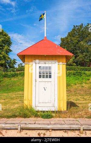 Idyllische alte Strandhütte mit der schwedischen Flagge oben Stockfoto