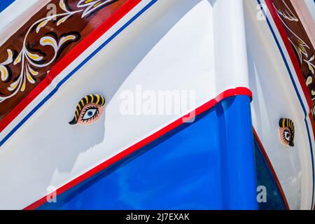 Farbenfrohe Luzzu-Boote, die im Mai 2022 am Rande des Wassers in Bugibba, Malta, gesehen wurden. Stockfoto