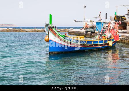 Luzzu Boot am Mellieha Hafen gesehen auf dem klaren Wasser des Mittelmeers im Mai 2022 während in Malta. Stockfoto