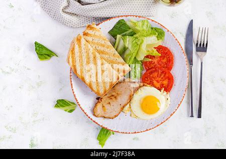 Spiegelei mit Schweinefleisch, Tomaten und Toast. Köstliches Englisches Frühstück. Brunch. Draufsicht, Overhead Stockfoto