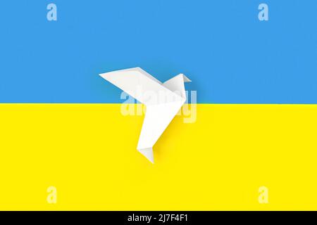 Zwei weiße Origami-Papiertauben auf Farben der Flagge der Ukraine. Das Konzept des Friedens zwischen zwei Staaten. Symbol des Friedens auf blauem und gelbem Hintergrund. Stockfoto