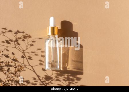 Naturölkosmetik auf neutralem Hintergrund. Tropfferglas Flasche Mock-up. Ölige kosmetische Pipette. Gesichts- und Körperbehandlung. Spa-Konzept. Stockfoto