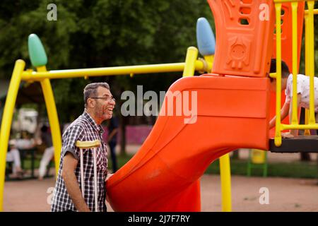 1. Mai 2022, Gaziantep, Türkei: Gaziantep, Türkei. 01 Mai 2022. Der syrische Großvater Kamal Khatib spielt mit seinem Enkelkind auf einem Spielplatz in Gaziantep. Kamal und sein Sohn Bashir wurden getrennt, als Kamal aus dem Krieg floh, um in Jordanien Zuflucht zu suchen. Erst 10 Jahre später, als Kamal in die Türkei reisen konnte, um sich wegen seiner sehr aggressiven Krebsform behandeln zu lassen, kam er mit seinem Sohn wieder zusammen, der jetzt mit seiner Frau und zwei kleinen Kindern in der Türkei lebt. Die Veranstaltung beleuchtet die Tragödie des Krieges in Syrien, bei dem die Syrer in einem nie endenden Konflikt gefangen sind und große Verluste, Vertreibung, und ein verursachen Stockfoto