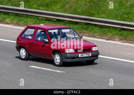 1992 90s Neunziger Jahre rot VAUXHALL Nova Life 993cc Benzin 2DR Fließheck; Fahren auf der M61 Autobahn, Manchester, Großbritannien Stockfoto