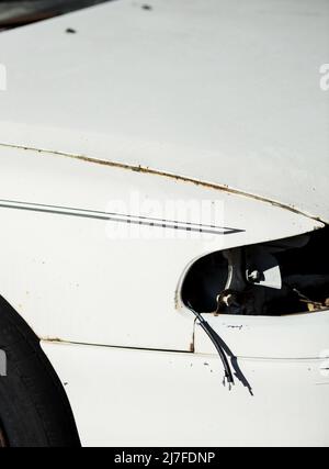 Beschädigtes rostiges Auto auf der Straße. Verformte Haube. Ohne Scheinwerfer Stockfoto