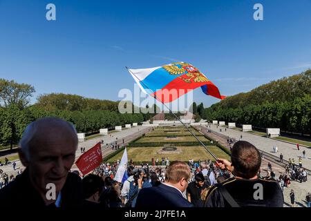 Berlin, Deutschland. 09.. Mai 2022. Am sowjetischen Denkmal im Treptower Park winkt ein Mann mit einer russischen Flagge. Quelle: Carsten Koall/dpa/Alamy Live News Stockfoto