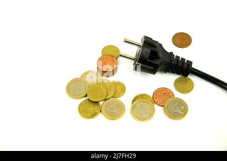 Schwarzer Stecker und Münzen auf weißem Hintergrund Stockfoto